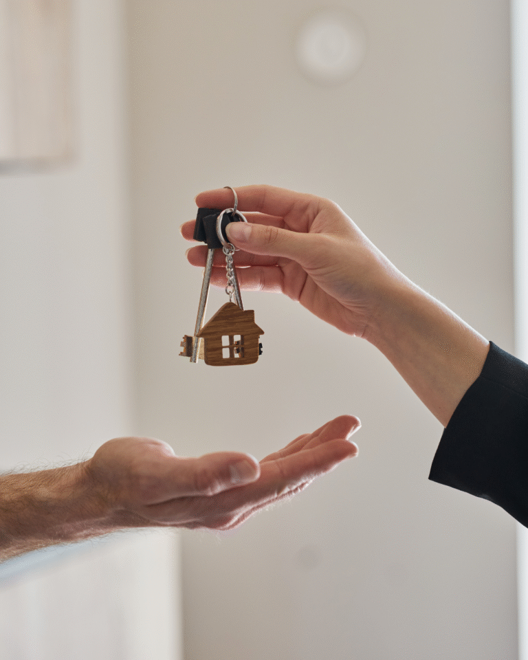A hand passing someone a set of house keys.